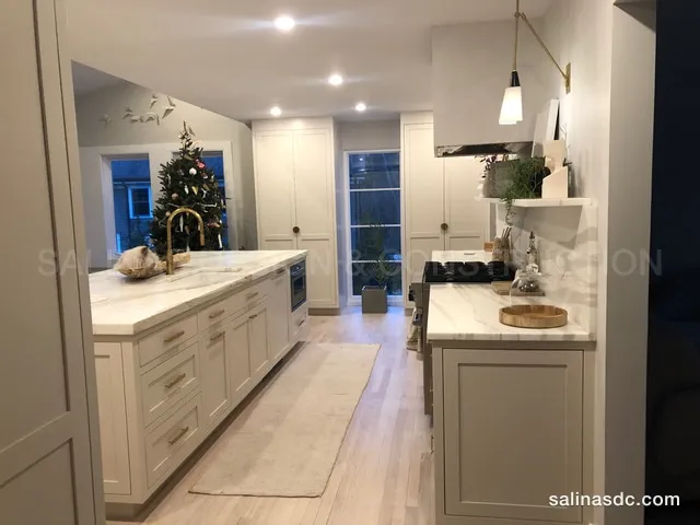 Custom galley kitchen with painted cabinetry and a marble island built to measure in Darien, Connecticut