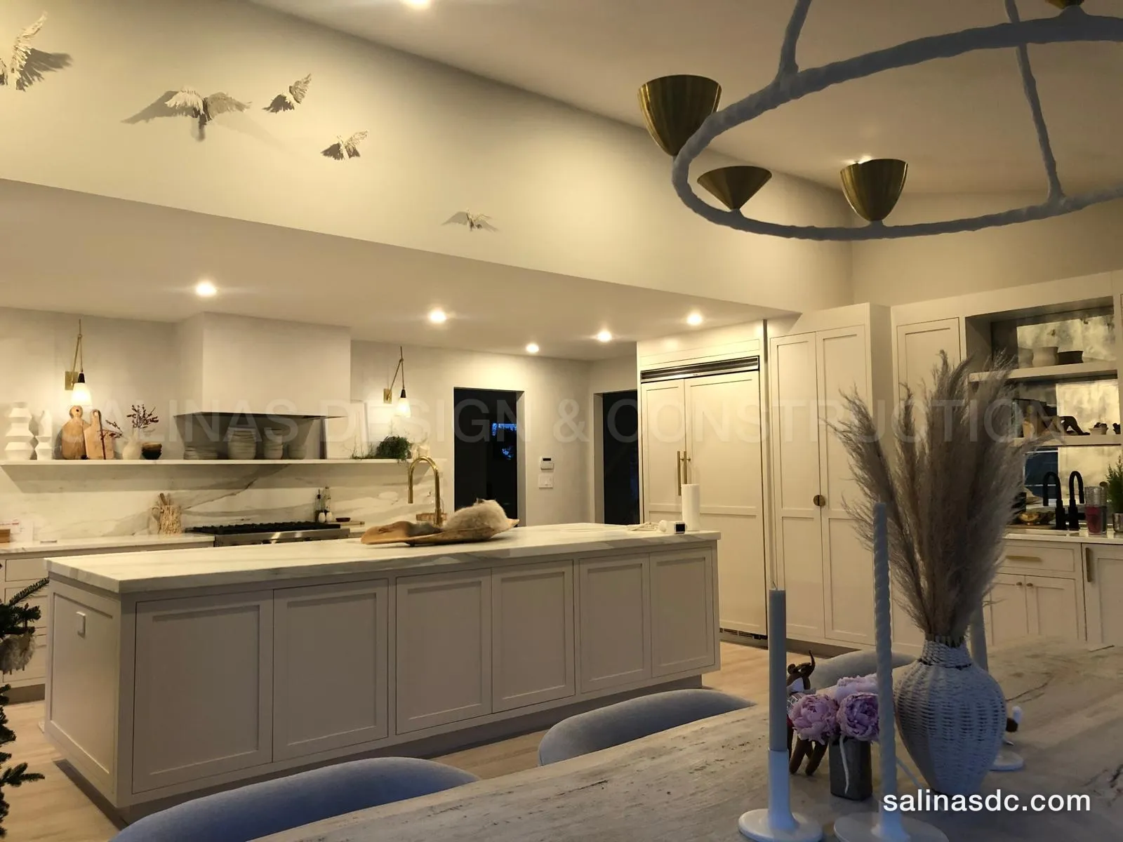 Custom kitchen cabinets in Darien, Connecticut: a long painted island, marble hood wall and full height cabinetry